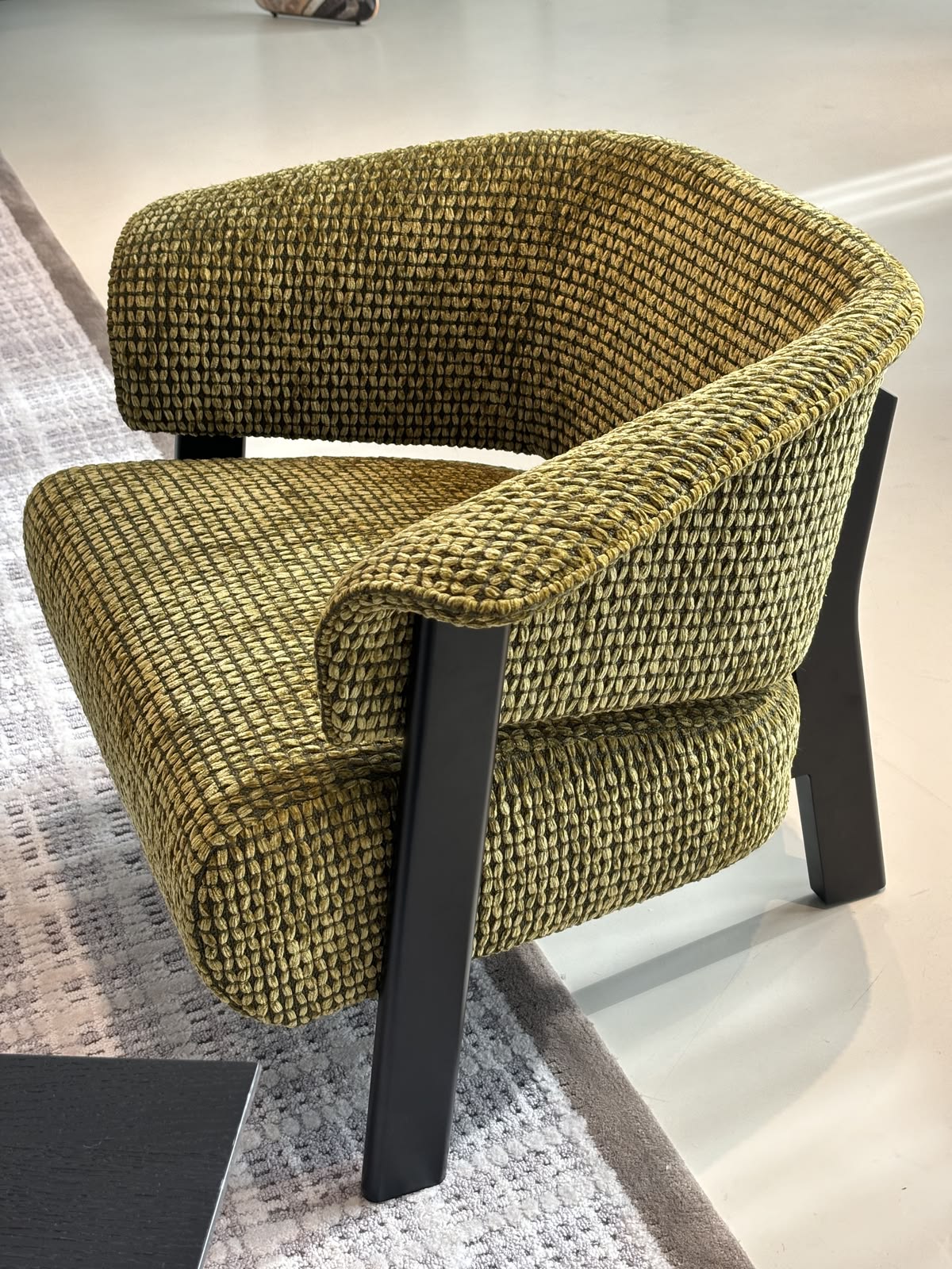 Olive bouclé armchair with angled black metal legs