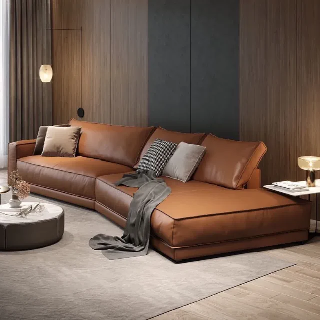 Tan leather sectional sofa with grey throw